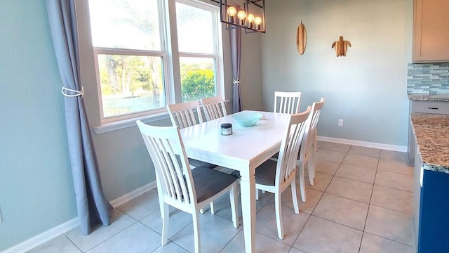 dining room featuring light tile patterned floors, a chandelier, and baseboards