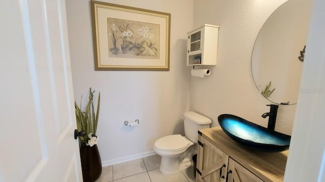 bathroom with toilet, tile patterned flooring, baseboards, and vanity