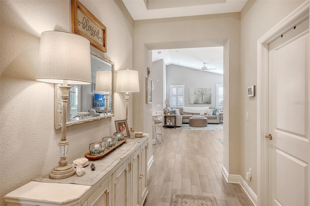 corridor featuring light hardwood / wood-style floors and vaulted ceiling