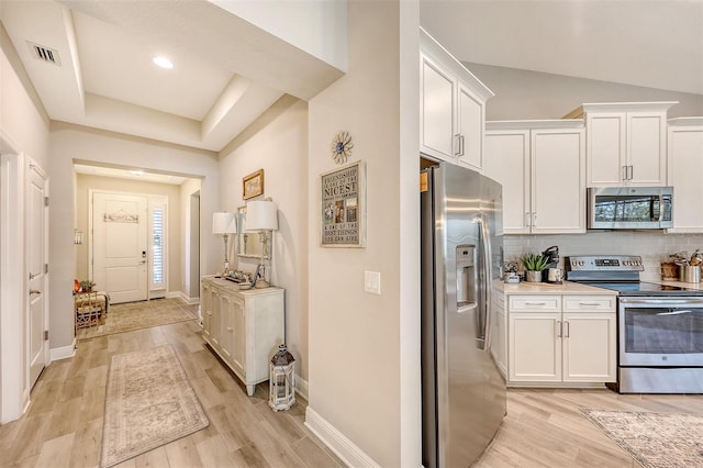 kitchen featuring white cabinetry, backsplash, appliances with stainless steel finishes, and light hardwood / wood-style flooring