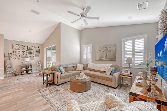 living room with a wealth of natural light, ceiling fan, lofted ceiling, and light wood-type flooring