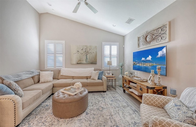 living room featuring ceiling fan, wood-type flooring, and vaulted ceiling