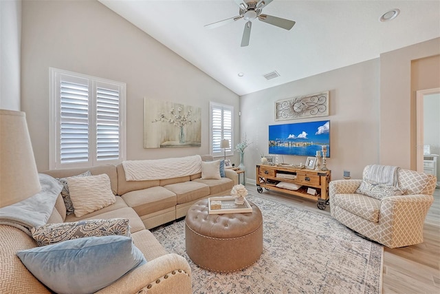 living room featuring hardwood / wood-style flooring, high vaulted ceiling, and ceiling fan