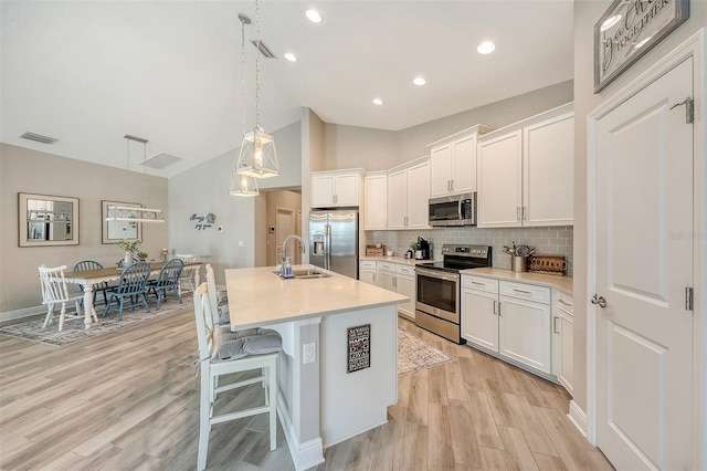 14924 Sora Way, Bradenton, FL 34212 - kitchen featuring stainless steel appliances, a sink, light wood-style flooring, light countertops, and an island with sink