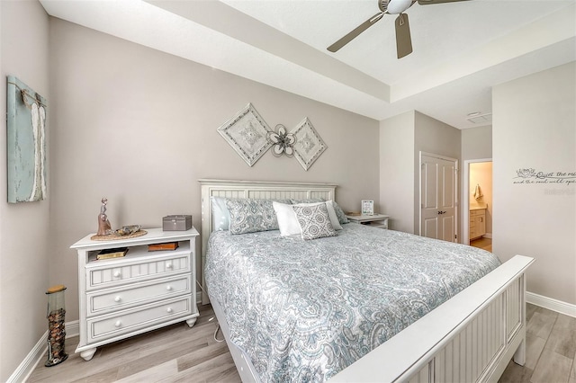 bedroom with light wood-type flooring, ensuite bathroom, and ceiling fan