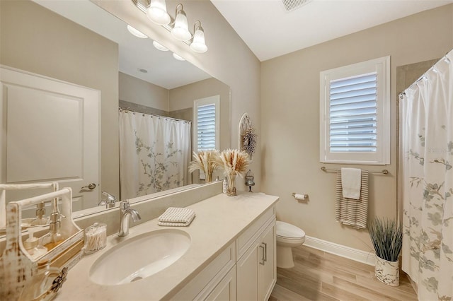 bathroom with vanity, wood-type flooring, and toilet