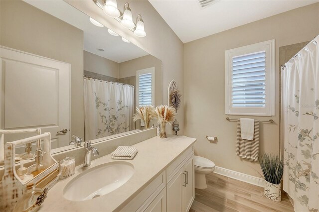 14924 Sora Way, Bradenton, FL 34212 - full bathroom with toilet, vanity, baseboards, wood finished floors, and a shower with curtain