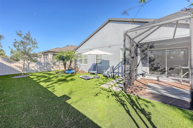 view of yard featuring glass enclosure and a patio area