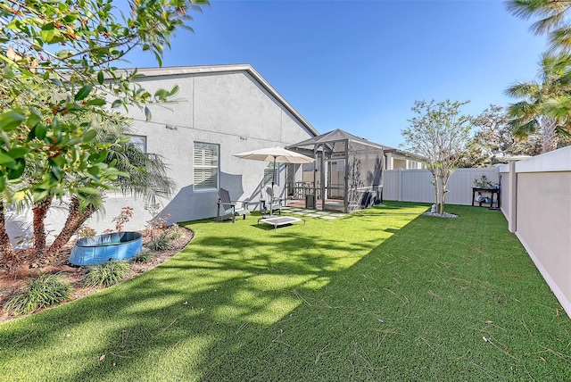 view of yard with a pool and glass enclosure