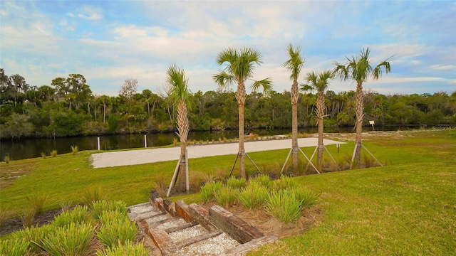 surrounding community featuring a water view and a lawn