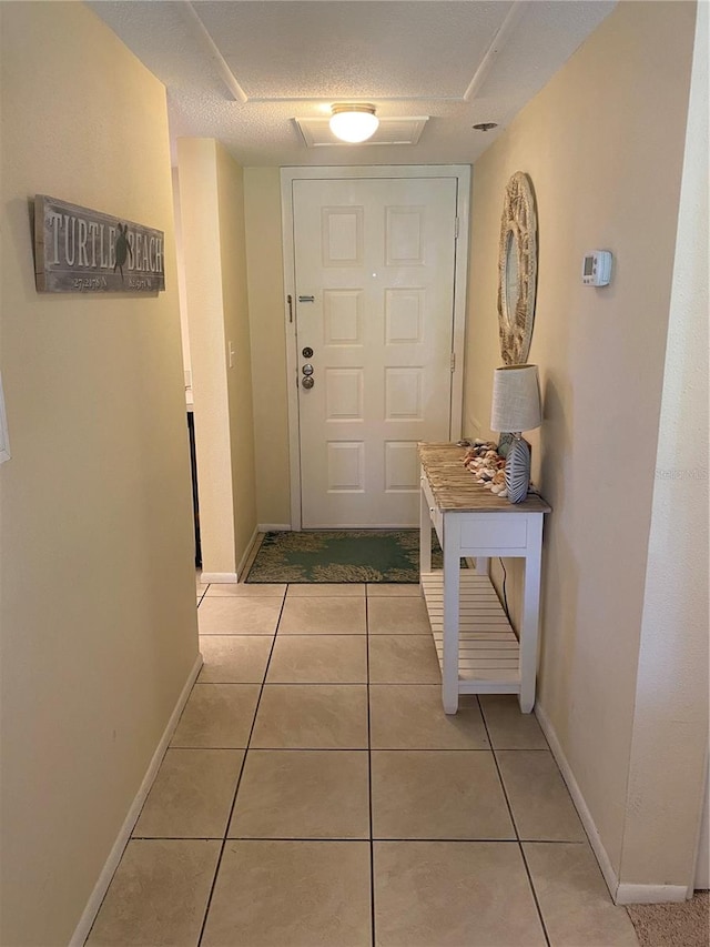 entryway featuring light tile patterned floors and a textured ceiling