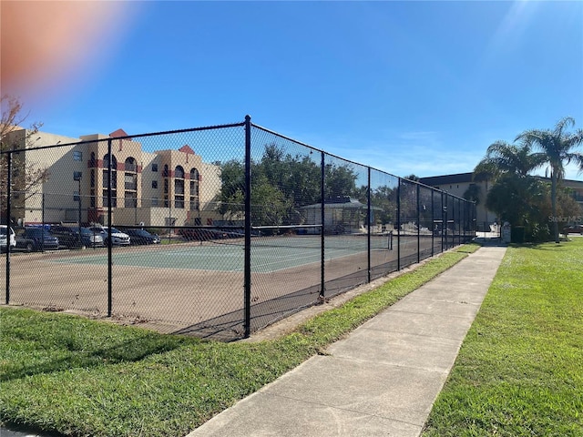 view of tennis court featuring a yard