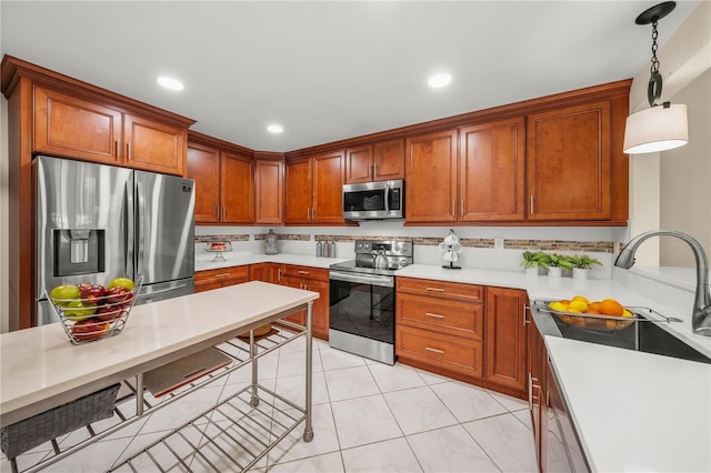 kitchen with appliances with stainless steel finishes, pendant lighting, and sink