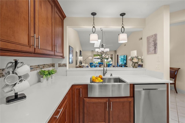 kitchen with sink, an inviting chandelier, stainless steel dishwasher, kitchen peninsula, and vaulted ceiling