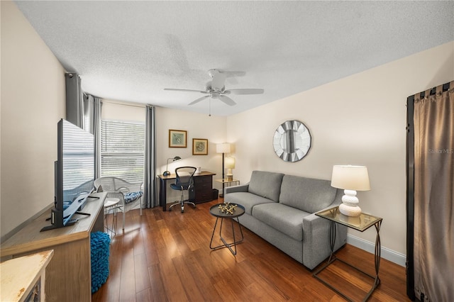 living room with a textured ceiling, dark hardwood / wood-style floors, and ceiling fan