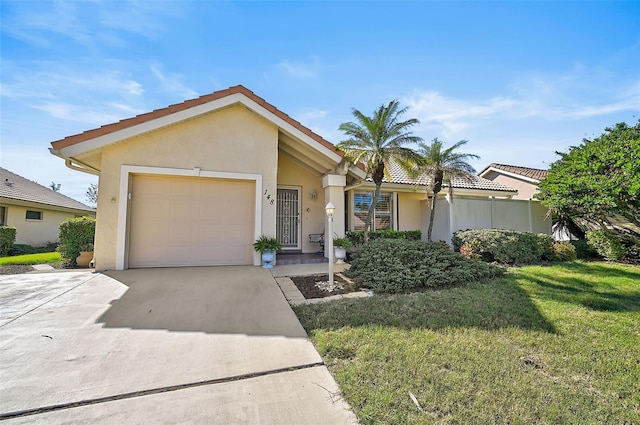 view of front of house with driveway, a garage, a tiled roof, a front lawn, and stucco siding