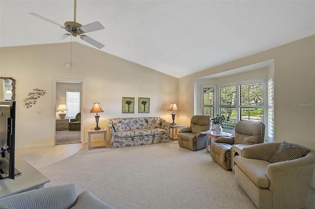 living room with light tile patterned floors, ceiling fan, vaulted ceiling, and light colored carpet