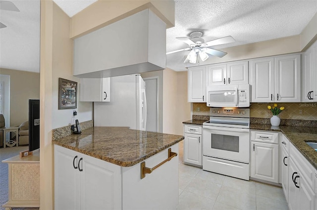 kitchen featuring white appliances, white cabinetry, backsplash, and a ceiling fan