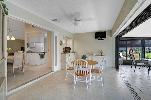 dining space featuring a ceiling fan, visible vents, and light tile patterned floors