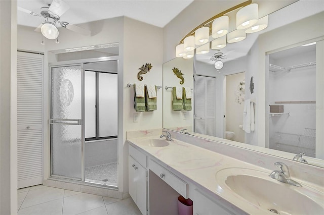 full bath with a shower stall, a sink, toilet, and tile patterned floors