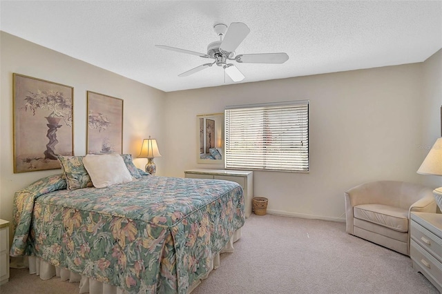 bedroom featuring light carpet, a textured ceiling, a ceiling fan, and baseboards