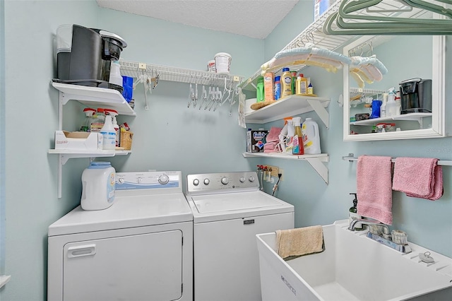 laundry room with laundry area, a sink, washer and clothes dryer, and a textured ceiling