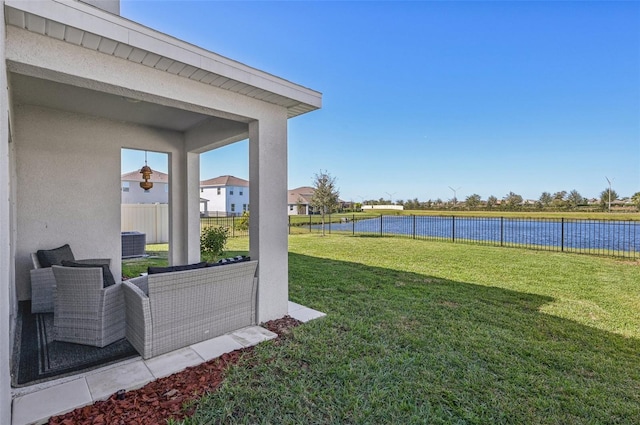 view of yard with a water view and central AC