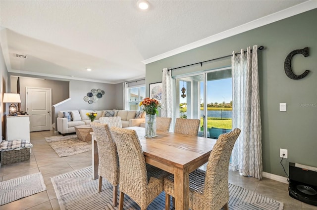 dining room featuring light tile patterned floors and crown molding