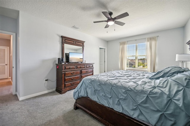 bedroom with a textured ceiling, ceiling fan, and light carpet