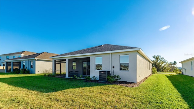 back of property featuring a yard, central air condition unit, and a sunroom