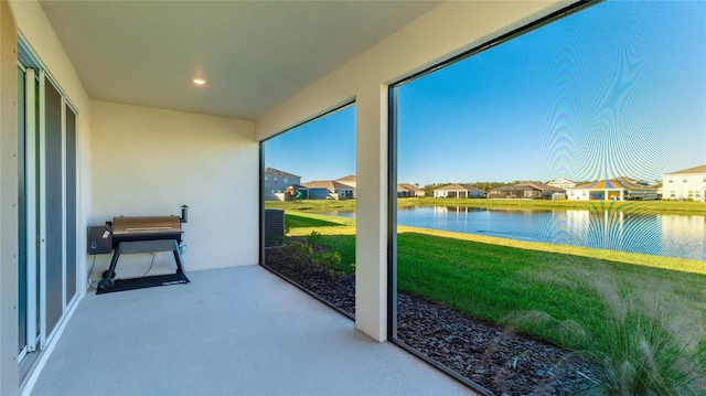 sunroom featuring a water view