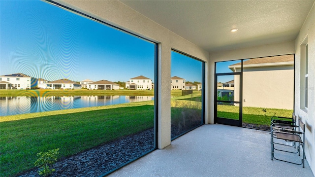 sunroom featuring a water view