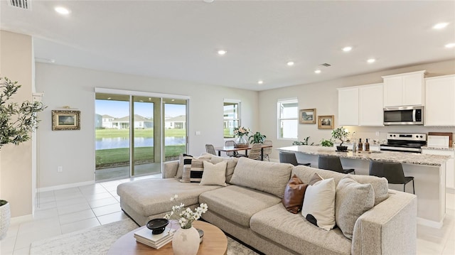 tiled living room with plenty of natural light and a water view