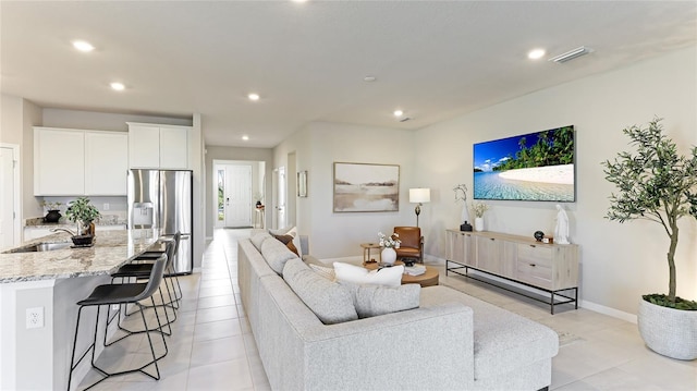 living room featuring sink and light tile patterned flooring