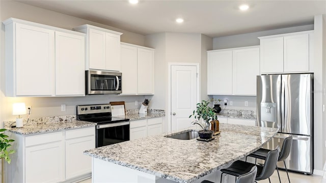 kitchen with white cabinetry, a kitchen island with sink, and appliances with stainless steel finishes