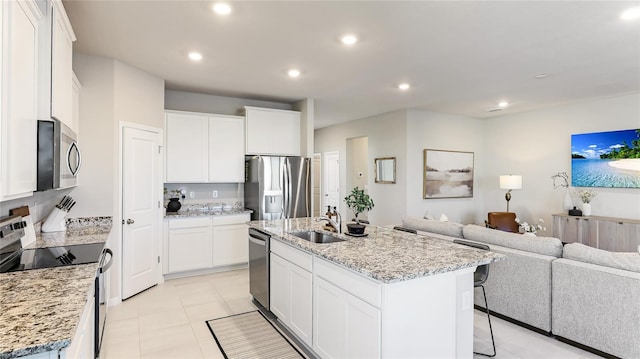 kitchen with sink, white cabinetry, a kitchen island with sink, and stainless steel appliances