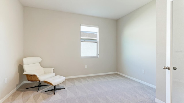 sitting room featuring light colored carpet