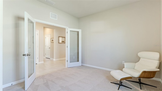 living area featuring french doors and light colored carpet