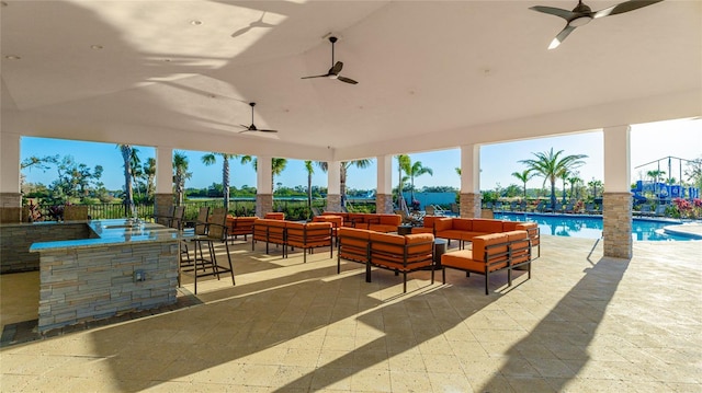 view of patio / terrace with outdoor lounge area, a bar, a water view, and ceiling fan