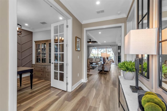 corridor featuring wood-type flooring, french doors, and ornamental molding