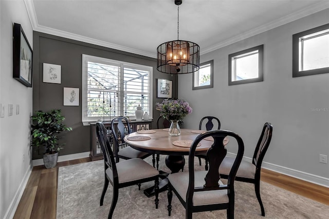 dining area featuring light wood-type flooring, a chandelier, and ornamental molding