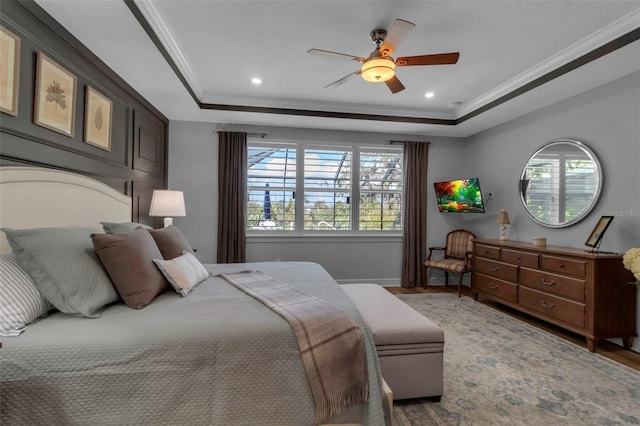 bedroom with ceiling fan, crown molding, and a raised ceiling