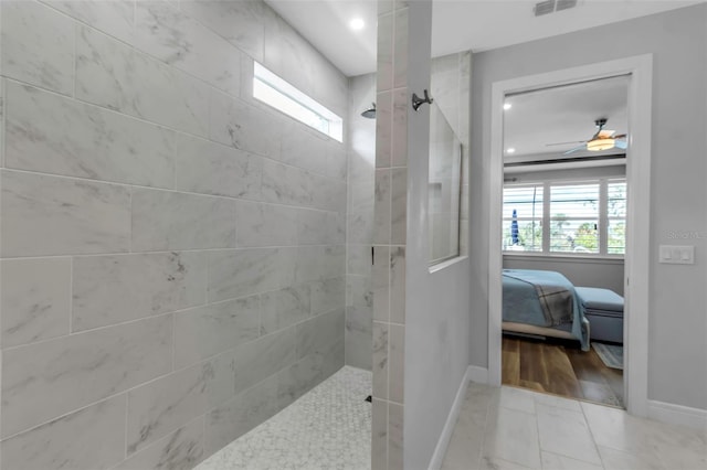 bathroom with ceiling fan and tiled shower