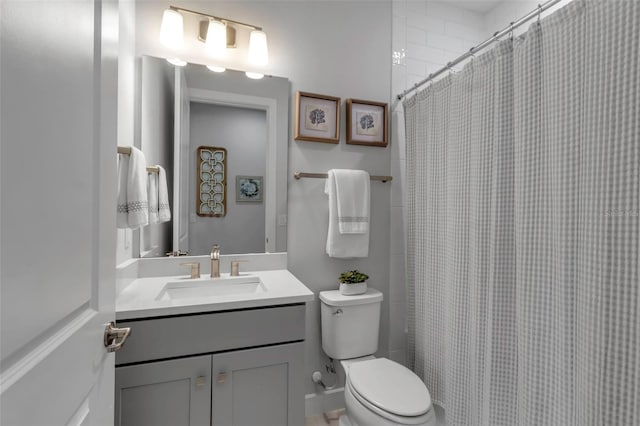 bathroom featuring curtained shower, toilet, and vanity