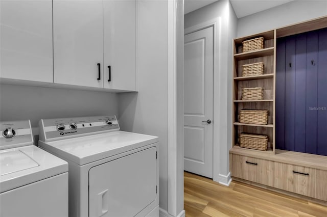 laundry room with light hardwood / wood-style flooring, cabinets, and separate washer and dryer