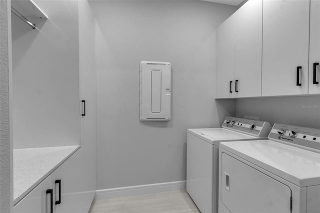 clothes washing area featuring cabinets, washer and clothes dryer, and electric panel