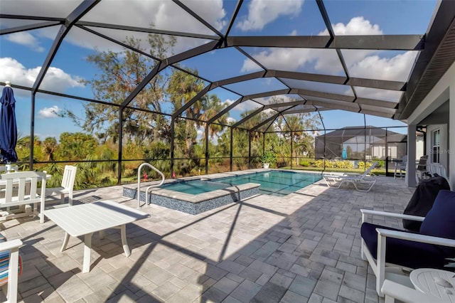 view of pool with an in ground hot tub, a lanai, and a patio area