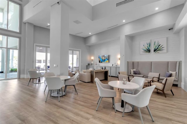 dining room featuring light hardwood / wood-style flooring and a high ceiling