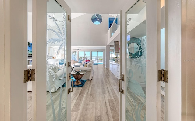 hall with french doors and light hardwood / wood-style flooring