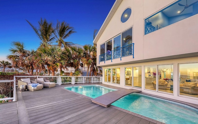 pool at dusk with a wooden deck